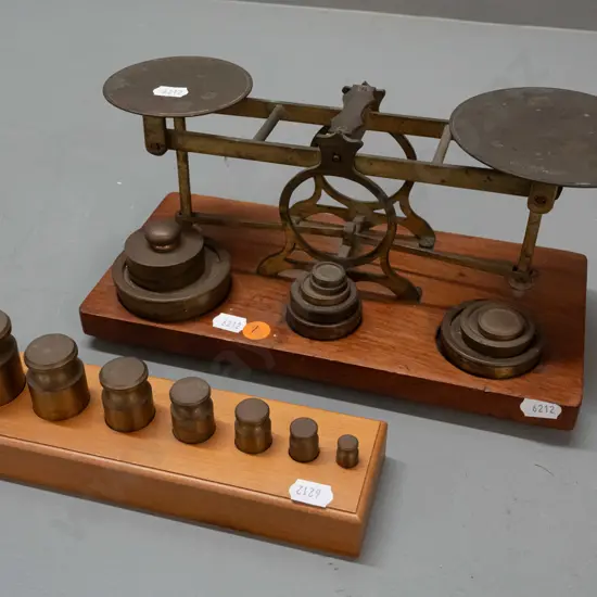 vintage brass balance scales on timber base with weights in fitted holes, one plate marked Waterlow & Sons London, plus