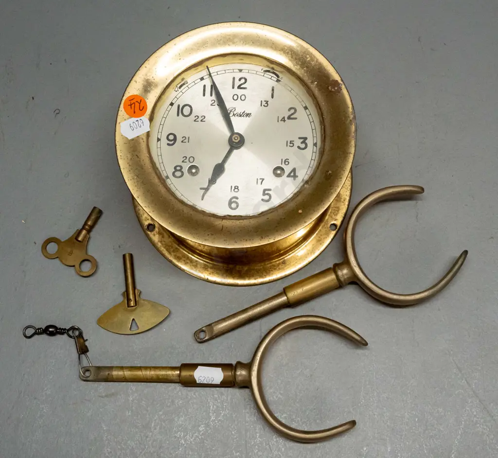 "Boston" brass ship's clock with screw-off face, 2 winding keys, strikes bells (working), and a  pair of brass rowlocks. Image 1++
