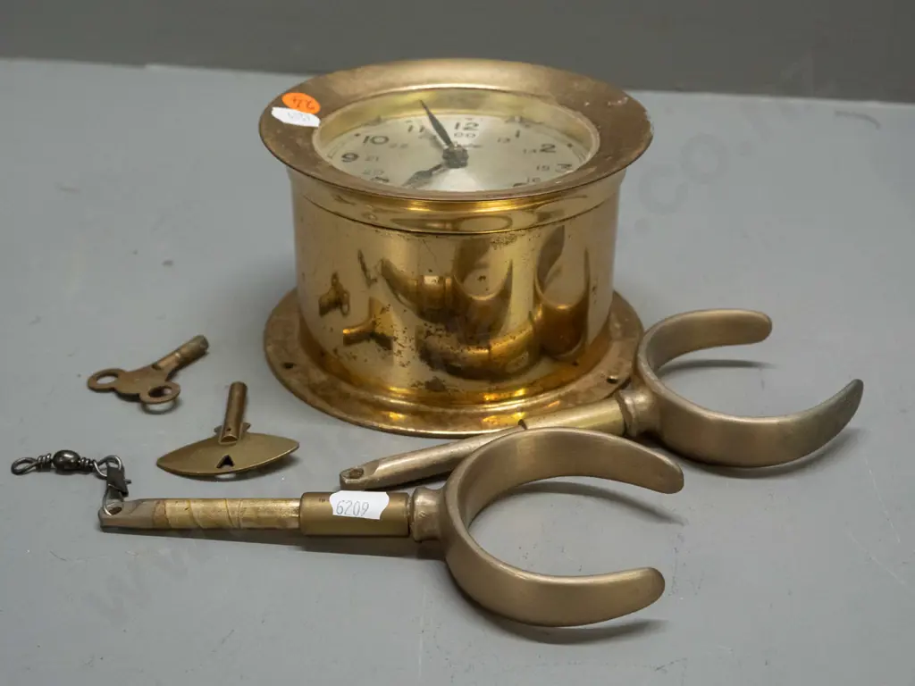 "Boston" brass ship's clock with screw-off face, 2 winding keys, strikes bells (working), and a  pair of brass rowlocks. Image 1++