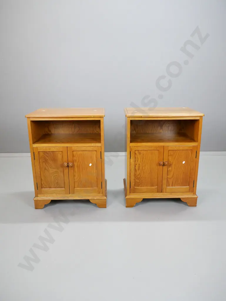pair of oak traditional style bedside cabinets with 2 panelled doors w/wooden knobs, bow front top, on bracket feet. Image 1++