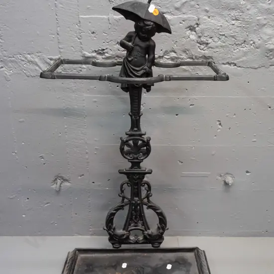 ornate cast metal umbrella stand with dolphins and child with umbrella motifs, 2 piece, both marked "Deponirt" - back