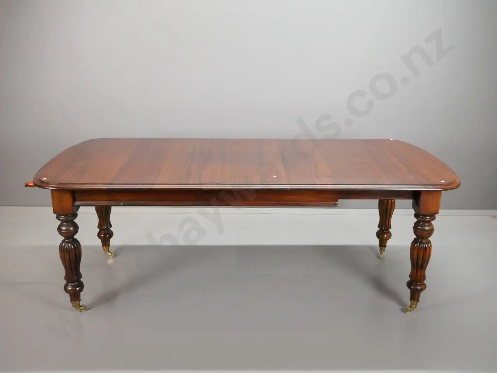 reproduction Victorian style mahogany dining table with turned and fluted legs, large brass cup casters, wind out handle Image 1++