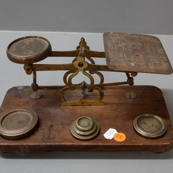 brass postal scales on timber base, with weights, plate is etched with postal rate information, indicator needle is