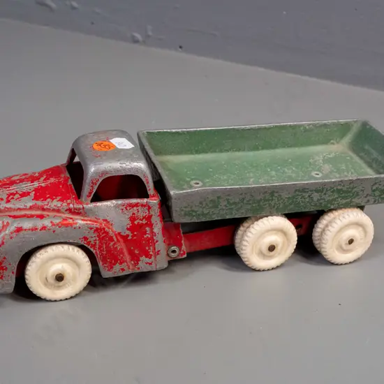 Fun Ho cast metal tip truck with white wheels, marked No. 502 on underside of tray. Paint wear and one door dented