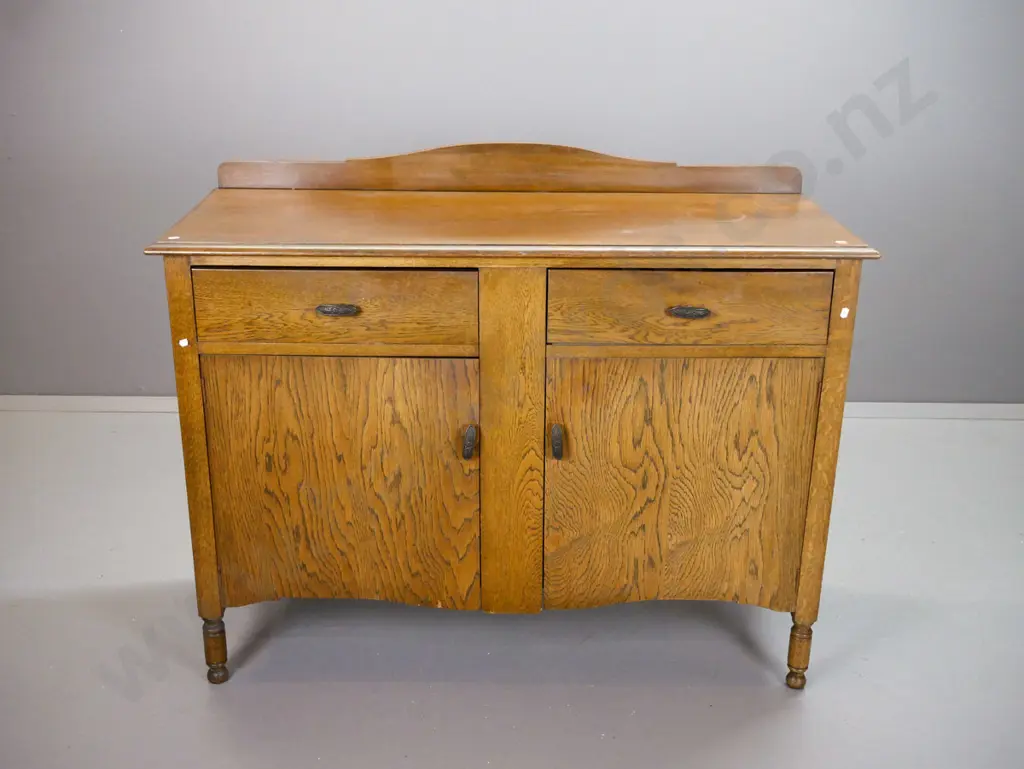 vintage oak 2-door 2-drawer sideboard with shaped back, panelled sides, embossed metal handles. Some water stains on top Image 1++