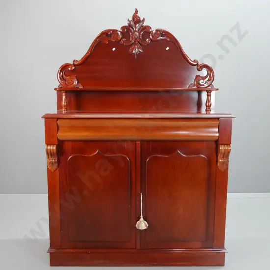 reproduction mahogany carved-back chiffonier, shaped top drawer above shield cupboard doors, 2 carved corbels, lock and
