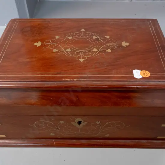 rosewood box with hinged lid, brass inlay and stringing, brass bound corners, bottom lined with green felt. Some