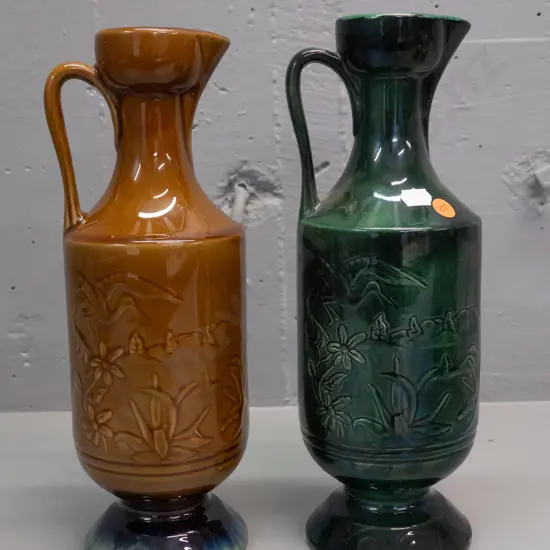 2 NZ ceramic handled ewer vases with heron motif designs - one marked Orzel and one Aquila Ceramics NZ H-310