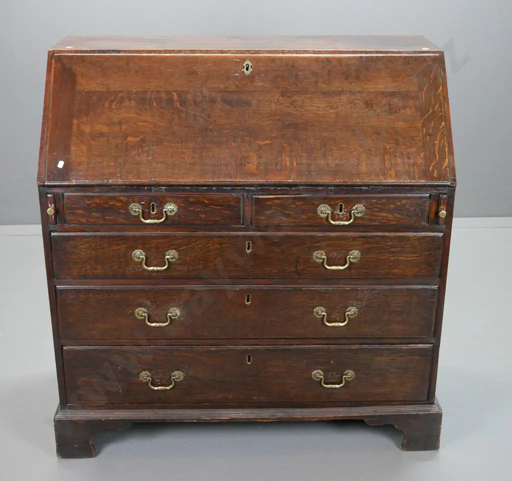 late Georgian oak bureau with 2 small and 3 large drawers, pigeonholes and 7 interior drawers, brass swan-neck handles Image 1++