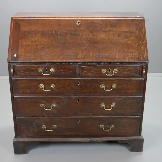 late Georgian oak bureau with 2 small and 3 large drawers, pigeonholes and 7 interior drawers, brass swan-neck handles