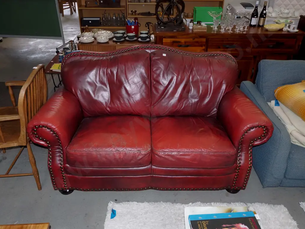 red leather rolled arm 2 seater settee with heavy dome studs -  wear and small tear to leather  Image 1++