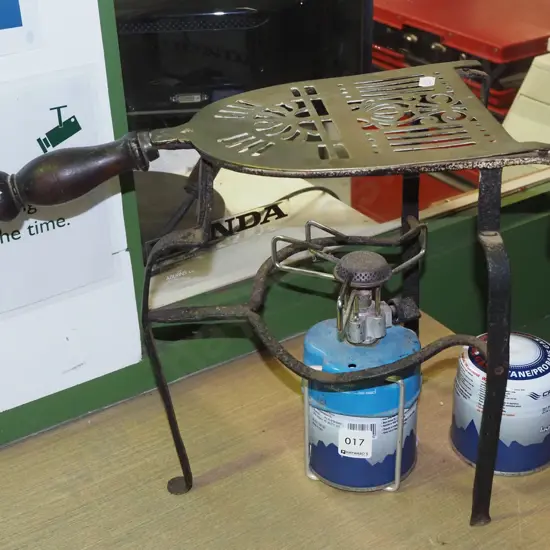 camp stove with additional gas canister, wooden handled brass trivet on stand