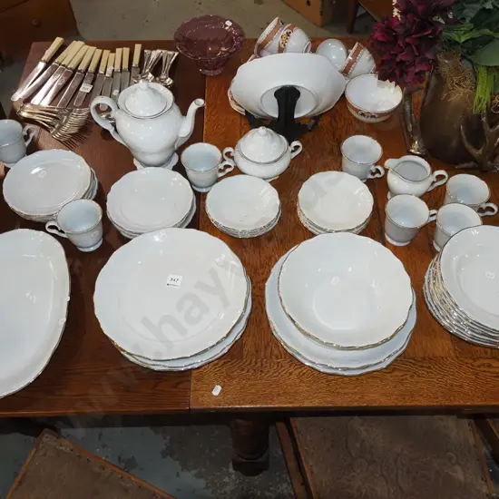 large assortment of white and gold rimmed dinner items