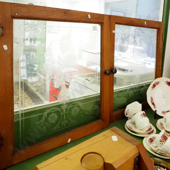 pair of glazed cupboard doors with floral etching and cast metal handles (small crack to 1 corner of one door)