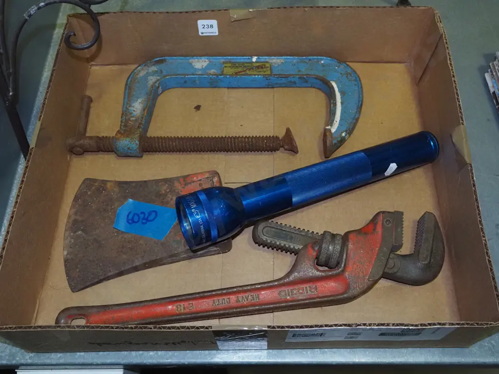 box; plumbers stilsons, large axe head, G clamp, mag light torch Image 1++