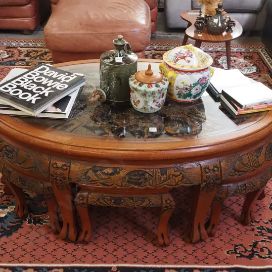 heavily carved Asian occasional  table with 6 pull out stools and oval glass top H-510 W-1200 D-720