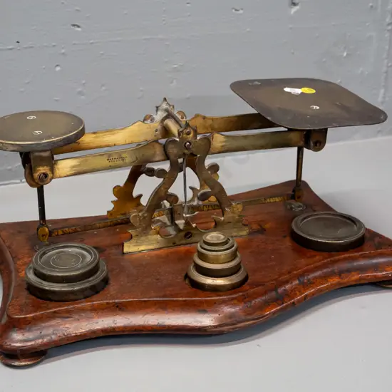 vintage large postal balance scales - brass mechanism and plates on mahogany or cedar base, with assorted brass weights.