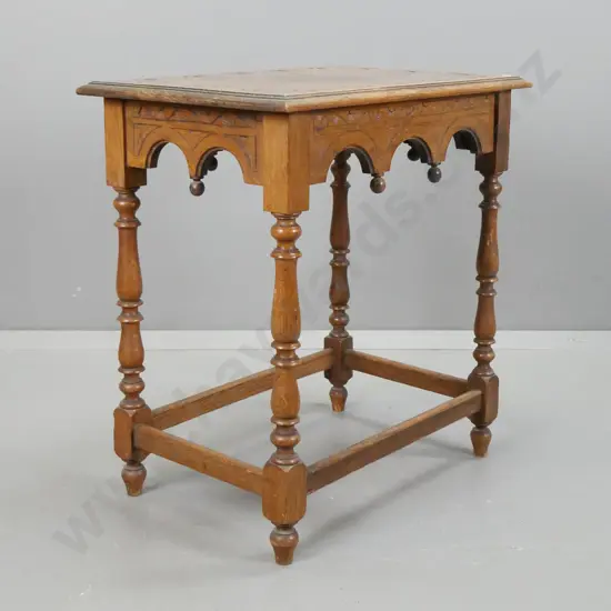 vintage carved oak side table with carved arches to side panels, turned legs, stretcher base, carved lunettes in top.