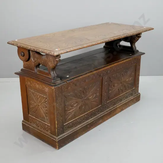 vintage Jacobean style oak monk's seat with carved foliate carved top & base panels, lion arm rests, seat back has