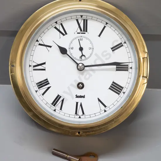 Sestrel brass-cased maritime style clock with winding key - marked British Made on face, some discolouration and