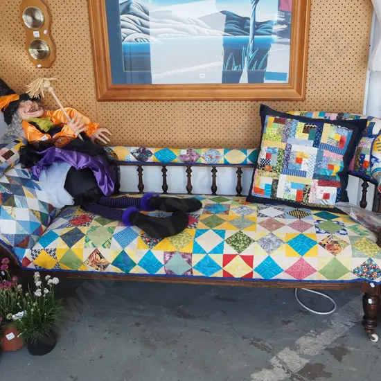 patchwork upholstered spindle back chaise longue on enamel casters with matching cushion