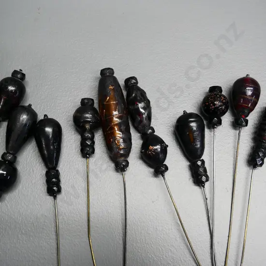 numerous vintage hat pins in fabric covered cushion - some are glass