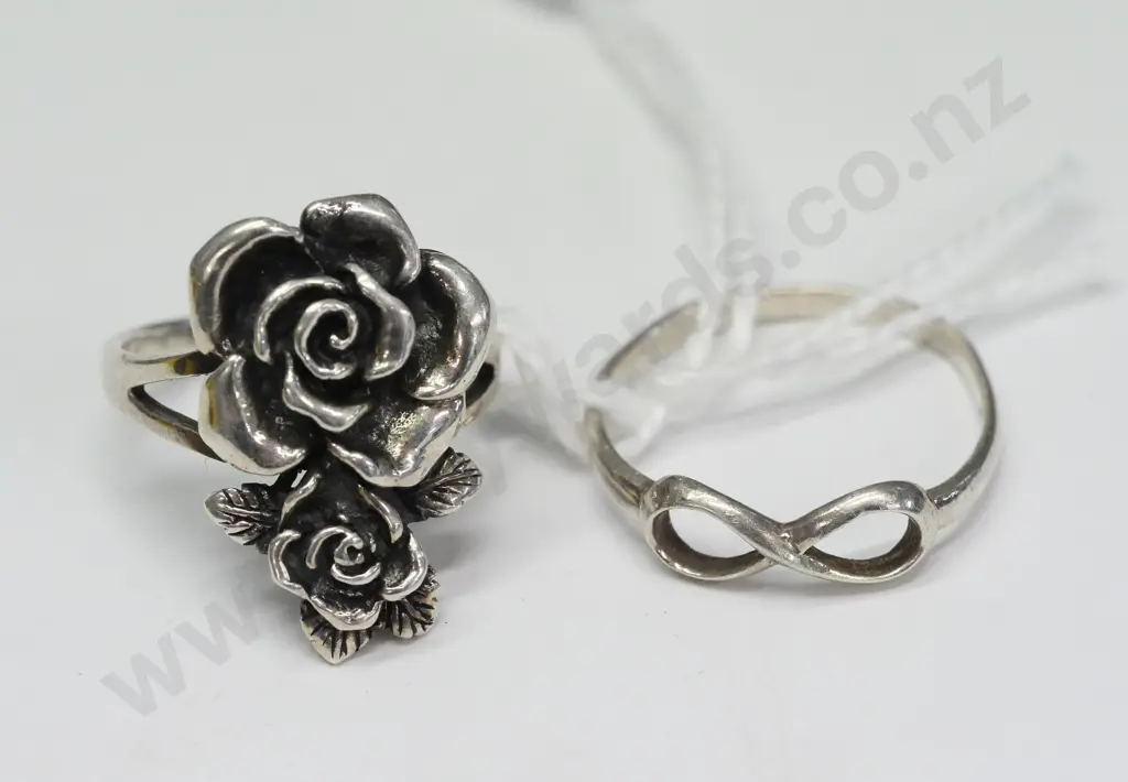 2 silver rings-1 with flowers both stamped 925 Image 1++