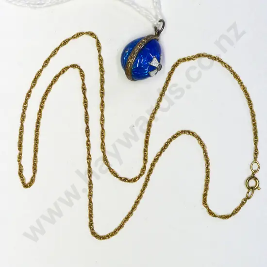 small blue enamel egg and a gold chain no markings