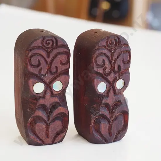 pair of carved tiki themed salt and peppers