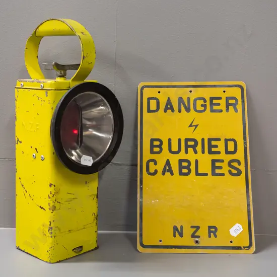 Vintage NZR signal lamp with rotating red/green lens mechanism. Small tin sign 'DANGER BURIED CABLES' NZR