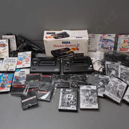 large Sega Master System II collection with 2 consoles, 2 handheld controllers, arcade pistol, numerous game cartridges