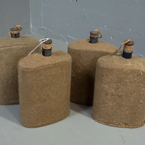 4x WWII-era enameled metal water bottles with felt covers and cork stoppers - insect damage to felt on one. H-210 W-150