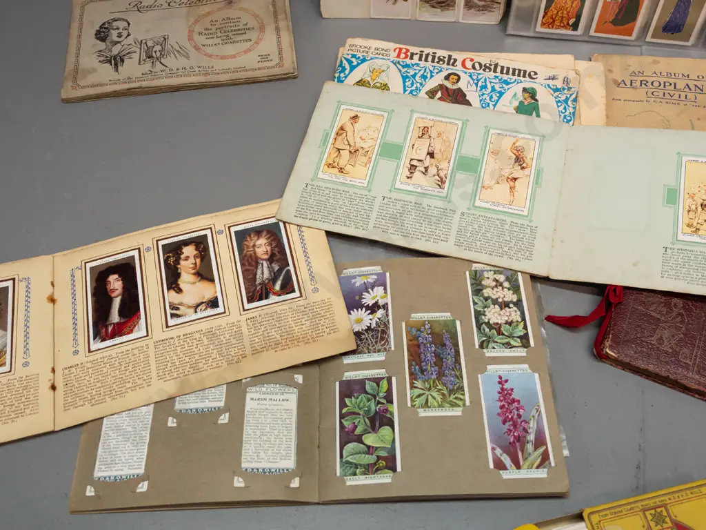 Assorted cigarette collector cards in sheets and albums, including a Wills cigarette box. Albums have partial contents Image 1++