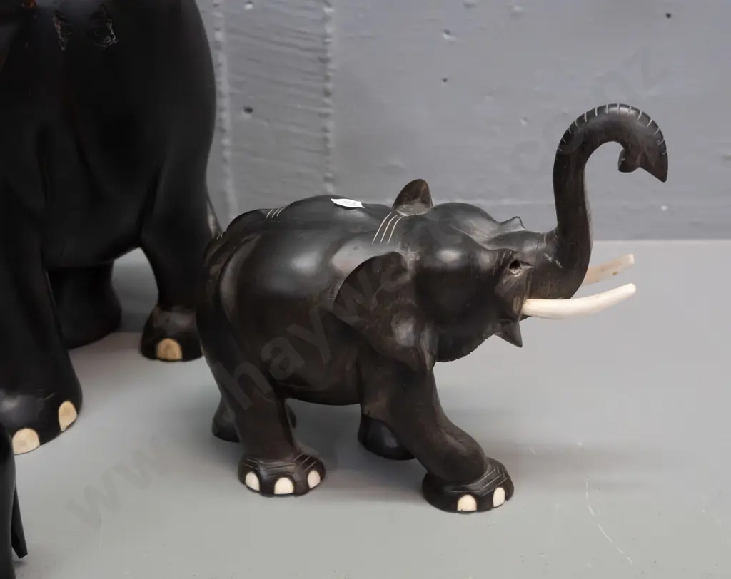 4 carved ebony elephants, varying styles - largest has crack through middle, one is missing eyes, one missing a tusk. Image 1++