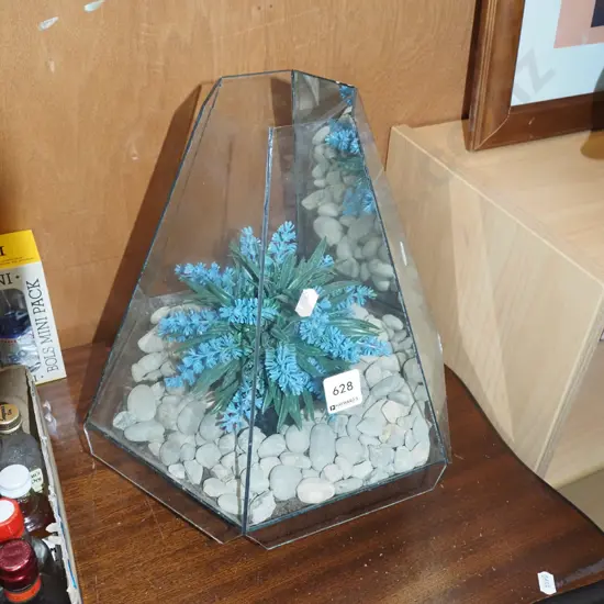 glass terrarium with stones and faux flowers