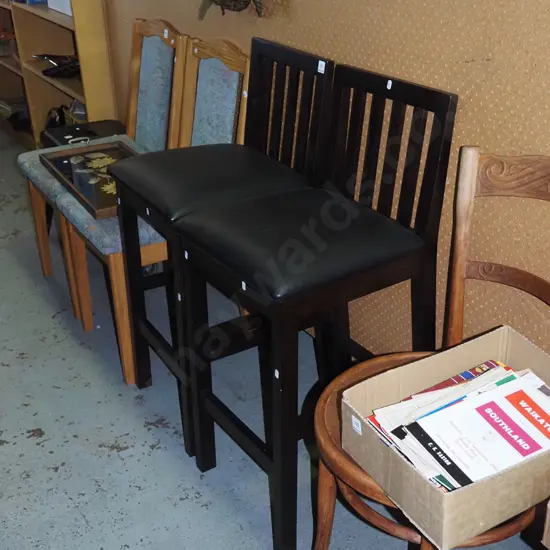 pair of dark stained black vinyl bar stools