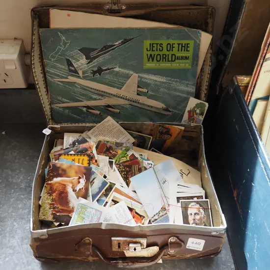 small battered suitcase with collector cards and albums