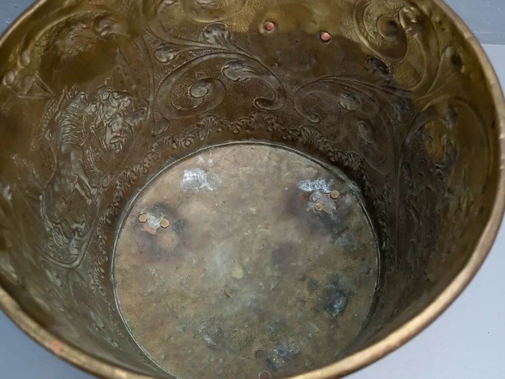 beaten brass jardiniere or wood bin with horse, windmill and heraldic motifs, with lion's head ring handles, on cast paw Image 1++