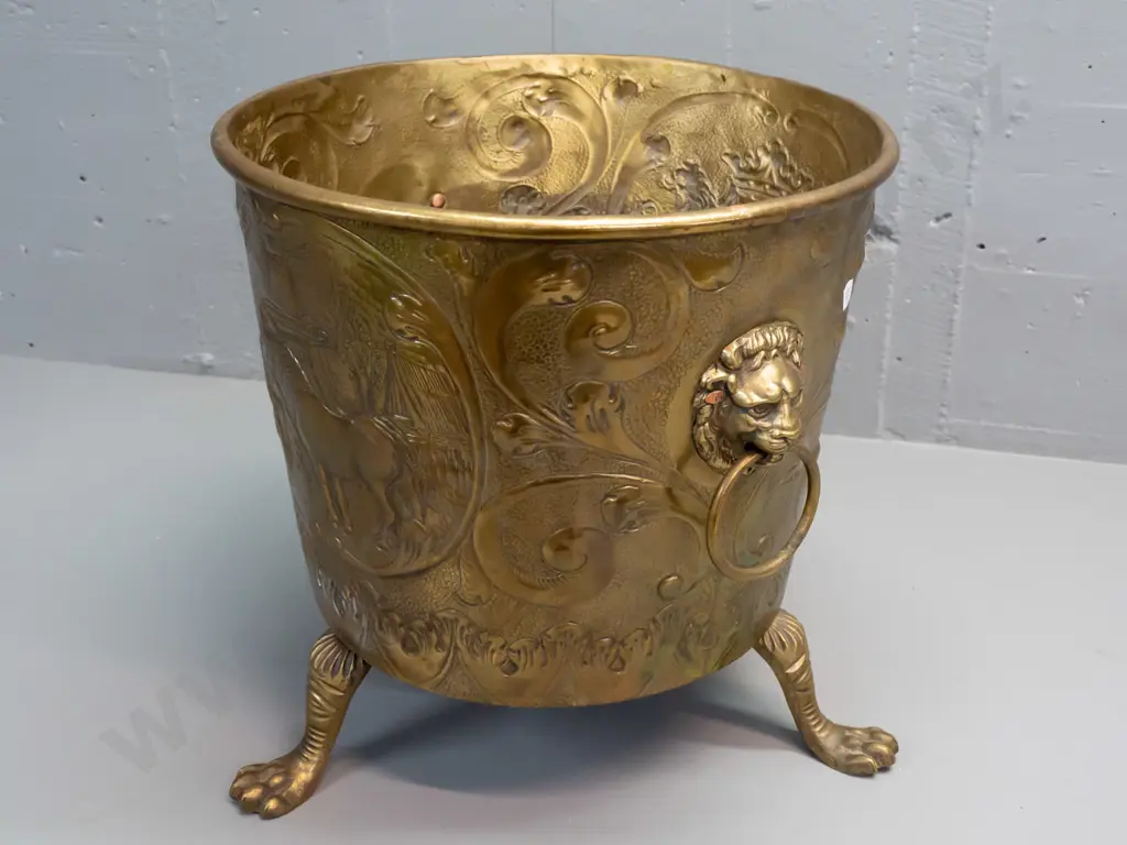 beaten brass jardiniere or wood bin with horse, windmill and heraldic motifs, with lion's head ring handles, on cast paw Image 1++