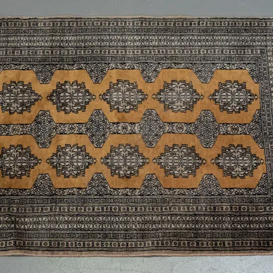 woolen floor rug, geometric boarders, mustard, blues & black colours, light weave & some fading L1520 W940