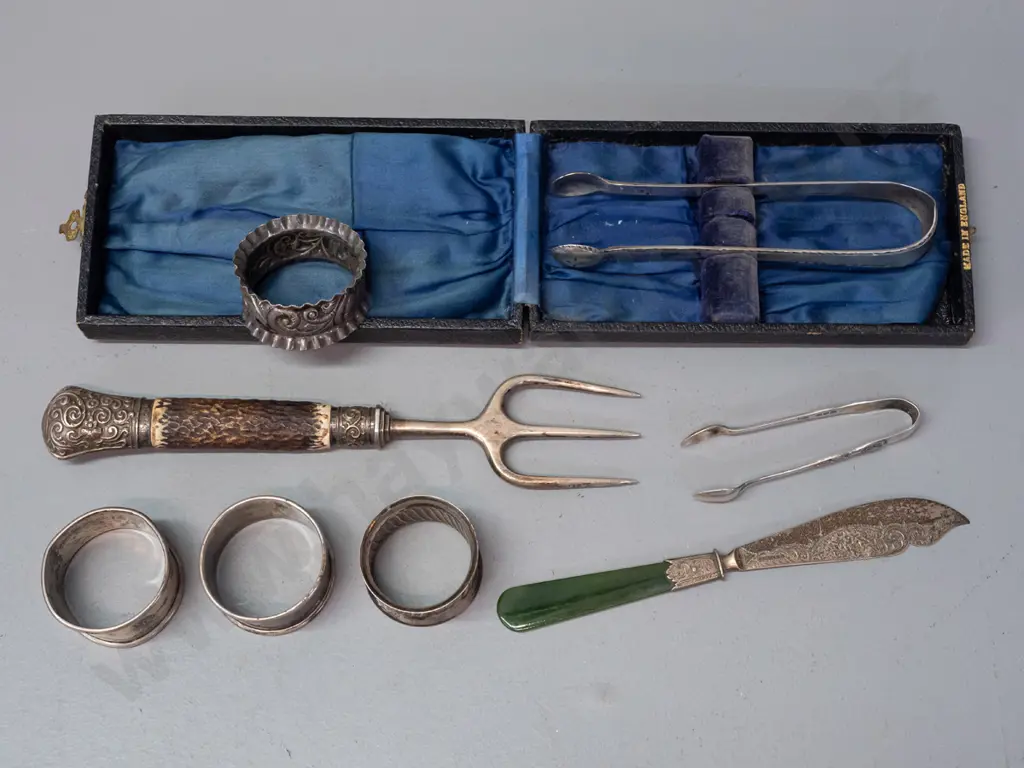 assorted silver napkin rings, sugar tongs, fork with antler handle and butter knife with greenstone handle - most marked Image 1++