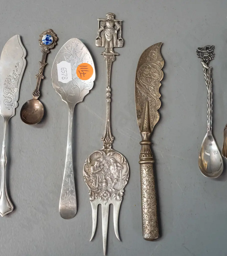 11 decorative and figural cutlery items, most hallmarked or marked sterling silver, one with porcelain ornament. Image 1++