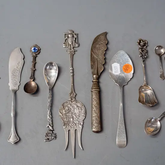 11 decorative and figural cutlery items, most hallmarked or marked sterling silver, one with porcelain ornament.