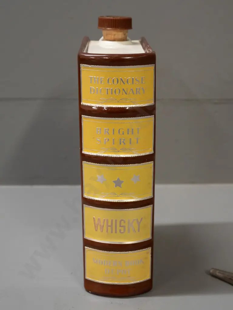 ceramic whisky flask in the shape of a book, with cork stopper and cork-fitted pourer. Some wear to label, tape Image 1++