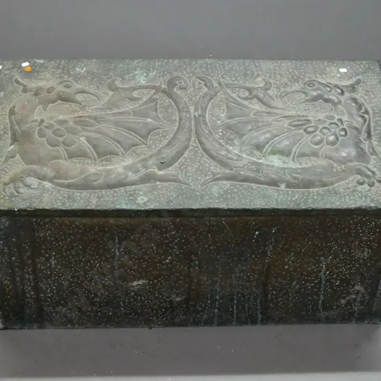 vintage hand-beaten brass woodbox, wood-lined, w/ intertwined dragons to slanted top. Deterioration to wood inside, rust