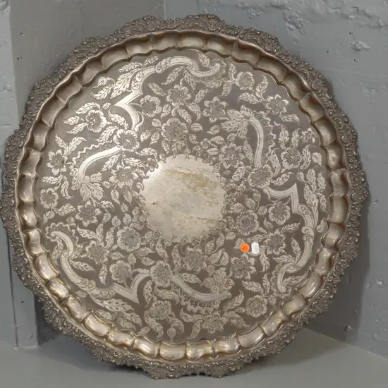 large silver plated circular footed serving tray with 3 scrolling feet and scroll shaped edge - some copper showing
