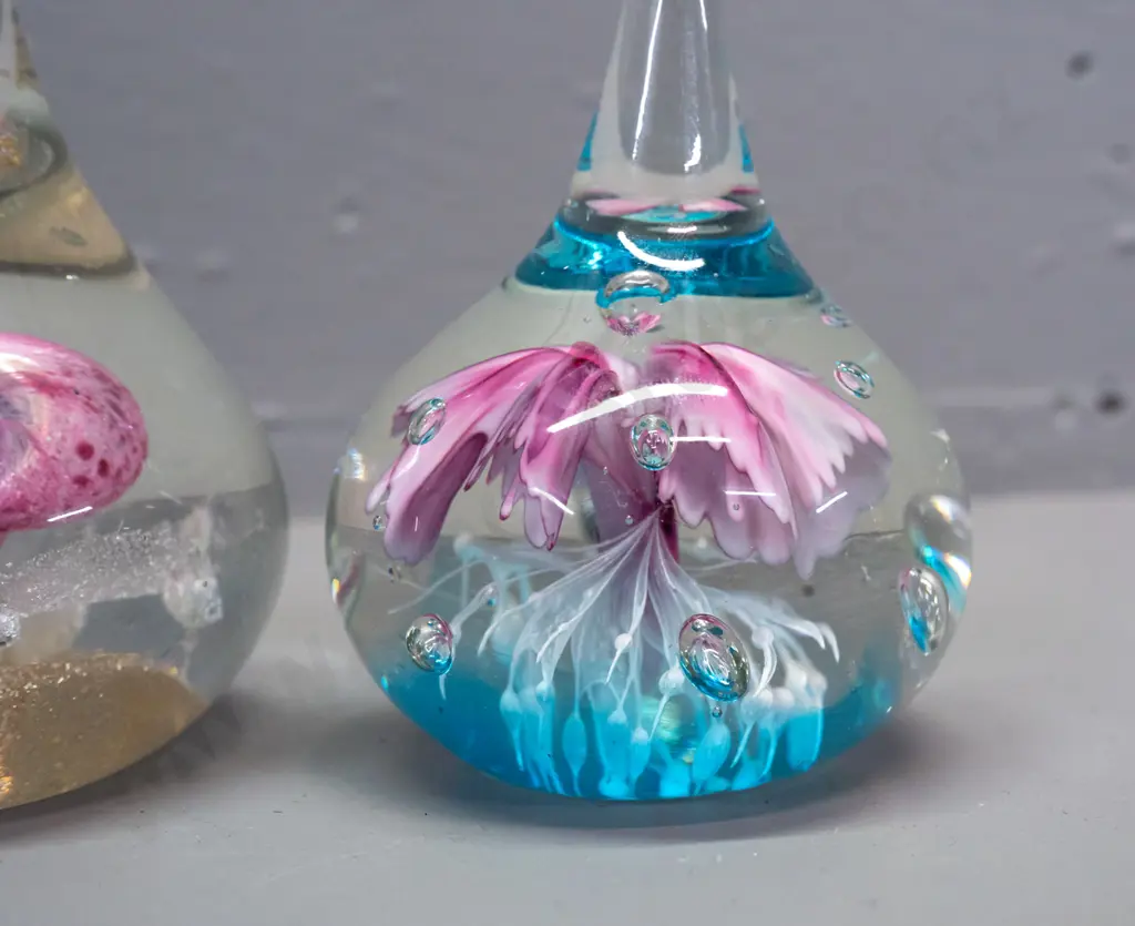 3 glass paperweights - 2 teardrop shaped with floral designs, taller is H-160, and a small Hokitika green bubble globe Image 1++