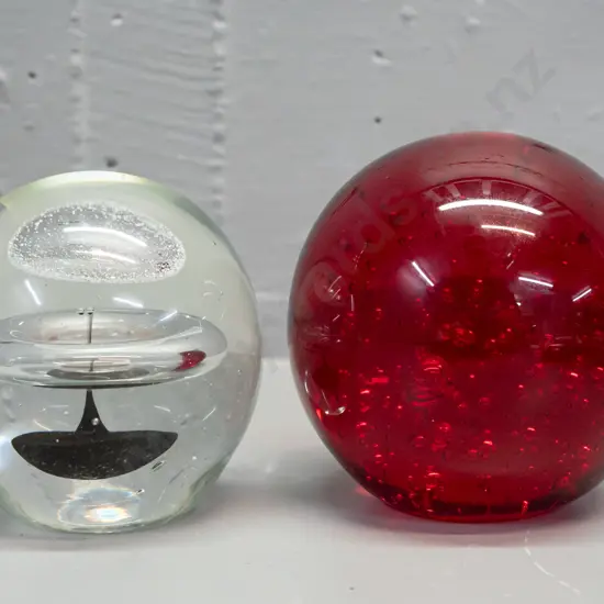2 heavy glass globe paperweights - red with bubbles has unreadable maker's mark on base and some scratches H-100