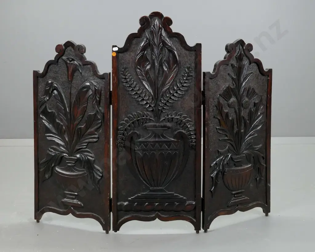 vintage dark-stained kauri carved 3-fold fire screen. Carved panels depicting urns holding Scotch thistle, lily, & fern Image 1++