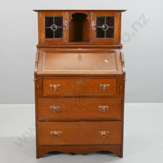 vintage arts & crafts style oak drop-front bureau with 3 lower drawers, 2 leadlight cupboard doors in top,